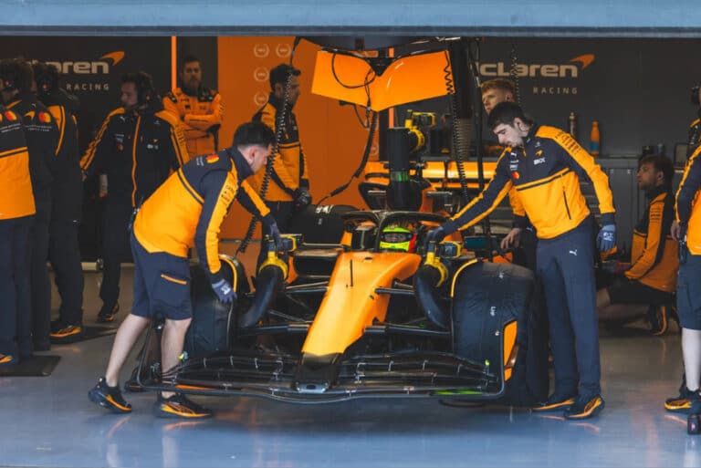 マクラーレンのガレージでピットレーンに並ぶF1マシンとクルー、シルバーストンでのTPCセッション中のレオナルド・フォルナローリ