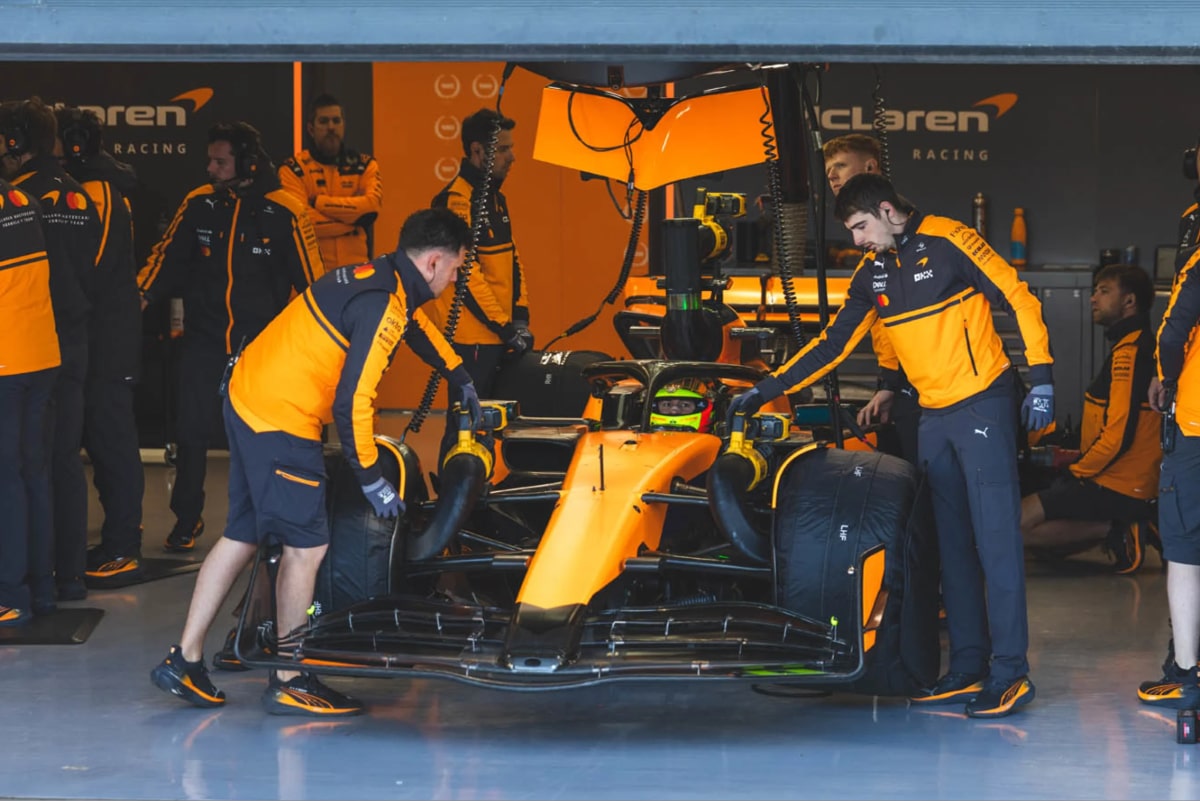 マクラーレンのガレージでピットレーンに並ぶF1マシンとクルー、シルバーストンでのTPCセッション中のレオナルド・フォルナローリ